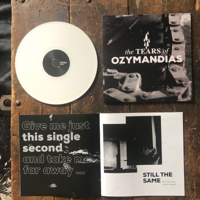 Disco de vinil branco, capa preta e branca do álbum the TEARS of OZYMANDIAS e livreto aberto