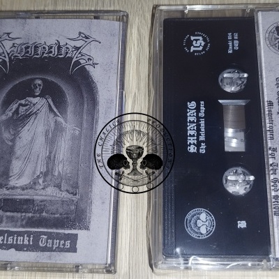 Duas cassetes de áudio pretas com capa e autocolantes numa mesa de madeira clara.