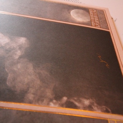 Poster ou página preta com borda laranja e manchas esbranquiçadas semelhantes a fumo