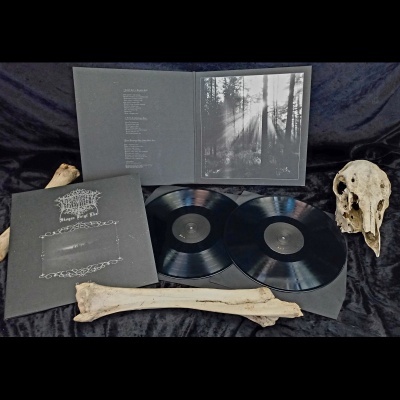 Caixa de vinil preta com discos, encarte e ossos, sobre fundo escuro