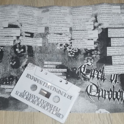 Cassete branca com etiquetas e recortes de texto colados em fundo preto e branco