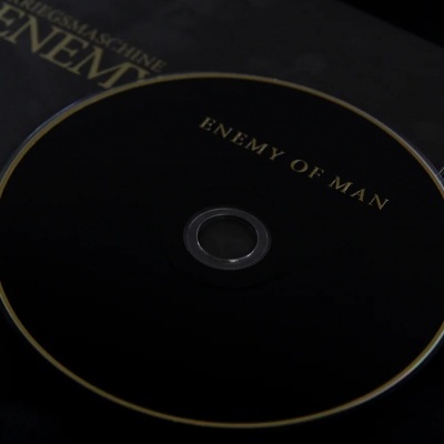 CD preto com texto dourado 'ENEMY OF MAN'