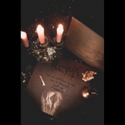 Candelabro com quatro velas acesas e objetos variados sobre superfície preta