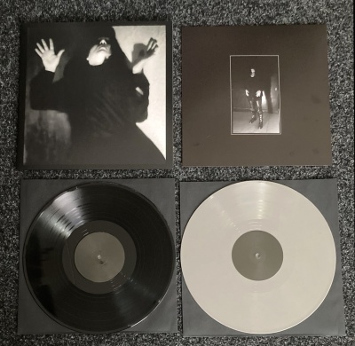 Dois discos de vinil, um preto e um branco, com duas capas fotográficas a preto e branco.