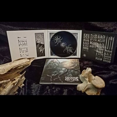 Pacote aberto de CD preto e branco com texto e desenhos ao lado de ossos de animal