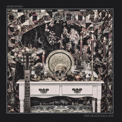 Altar decorativo com caveira, castiçal, guitarra e tecidos estampados.