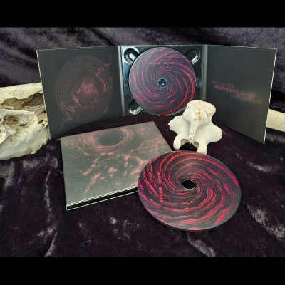CD com digipak preto e vermelho em superfície preta com ossos claros