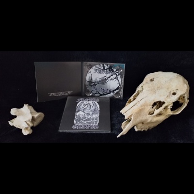 CD com capa e disco pretos e brancos entre dois crânios de animais sobre fundo preto.