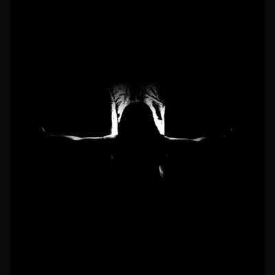 Figura humana em contraluz com braços estendidos