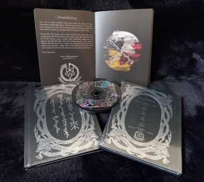 Conjunto de dois livros, CD e folheto aberto com textos e ilustrações em fundo preto