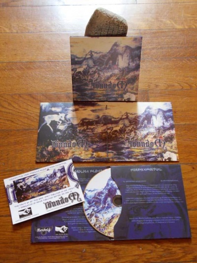 CD e material promocional do álbum Mundo G7 sobre chão de madeira.