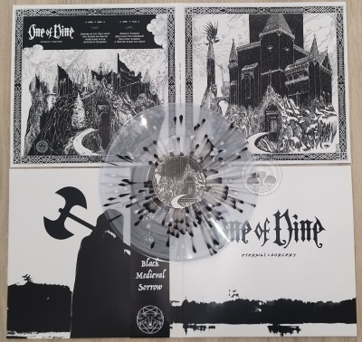 Vinil transparente com manchas pretas sobre capa de álbum em papel com arte a preto e branco e texto One of Time