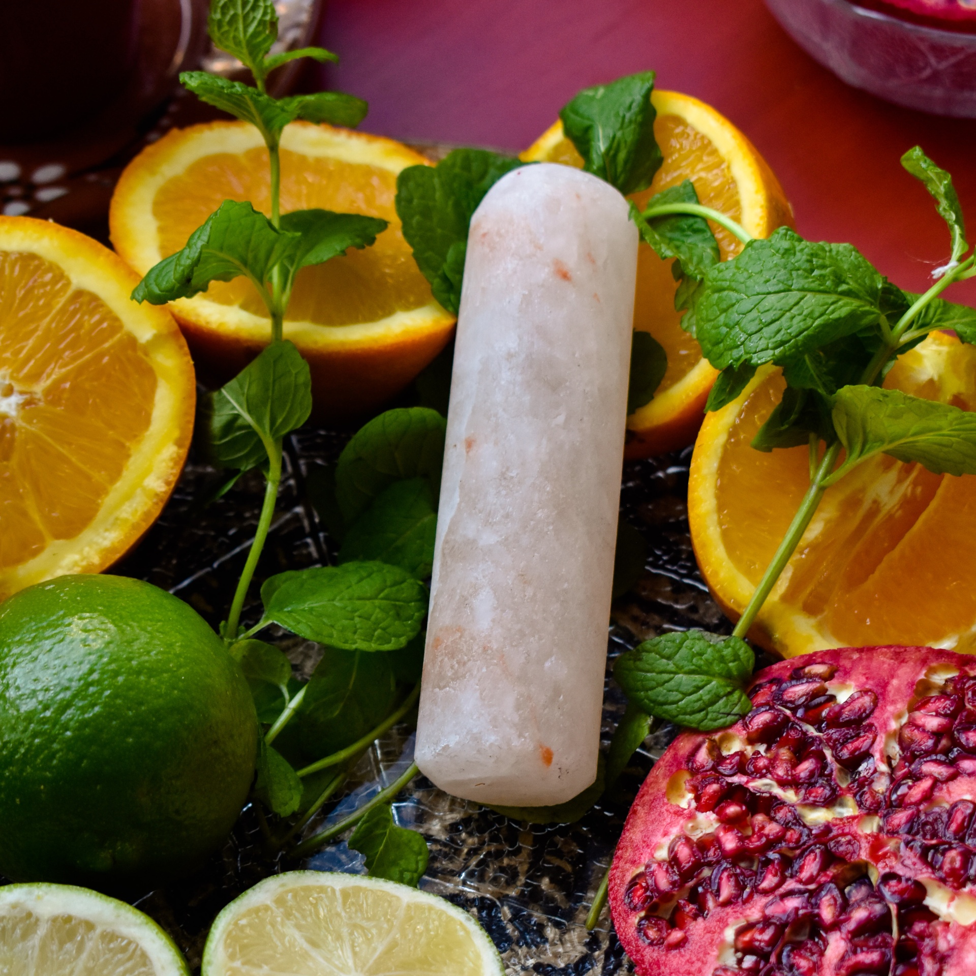 Desodorizante natural de Sal dos Himalaias Gelado em barra branco rodeado de fruta e folhas verdes