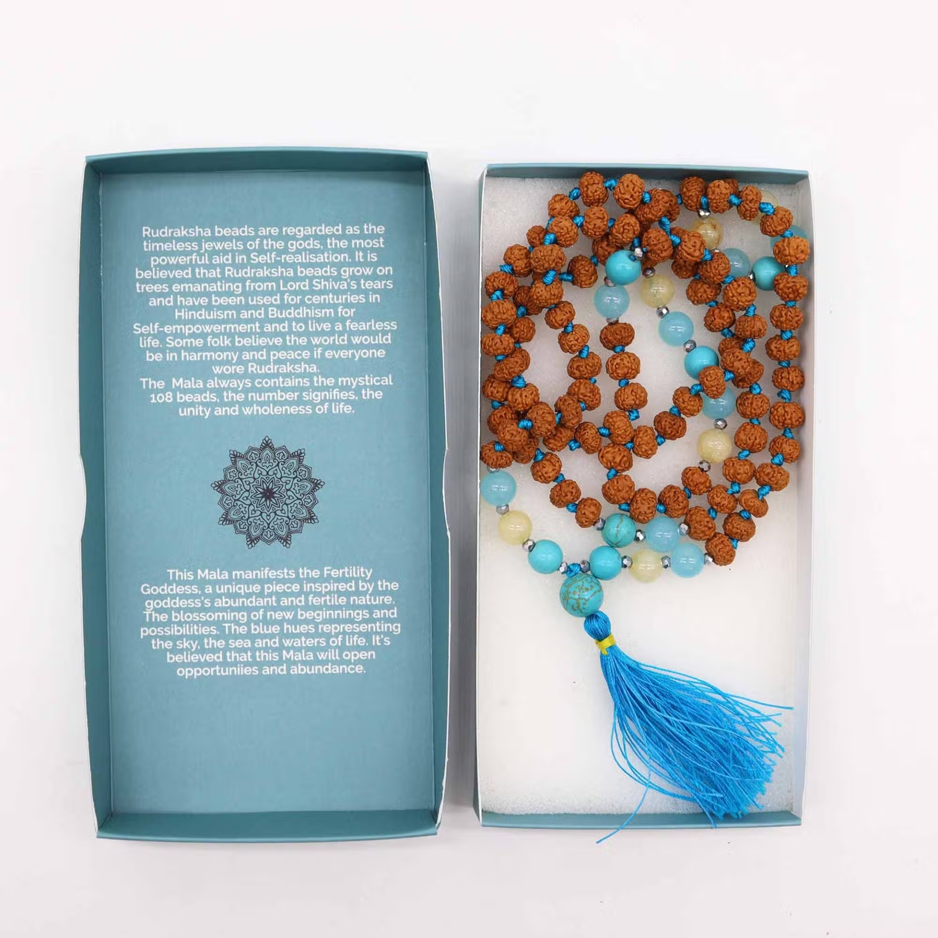 Colar Mala com contas rudraksha e pendente azul em caixa azul com texto