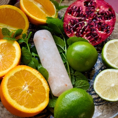 Frutas cortadas com palito de gelo em superfície de vidro