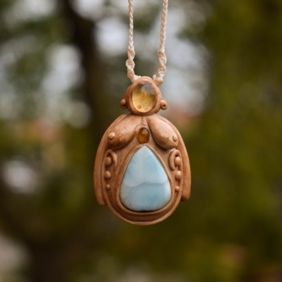 Colar artesanal em madeira com pedras azul e amarela pendurado