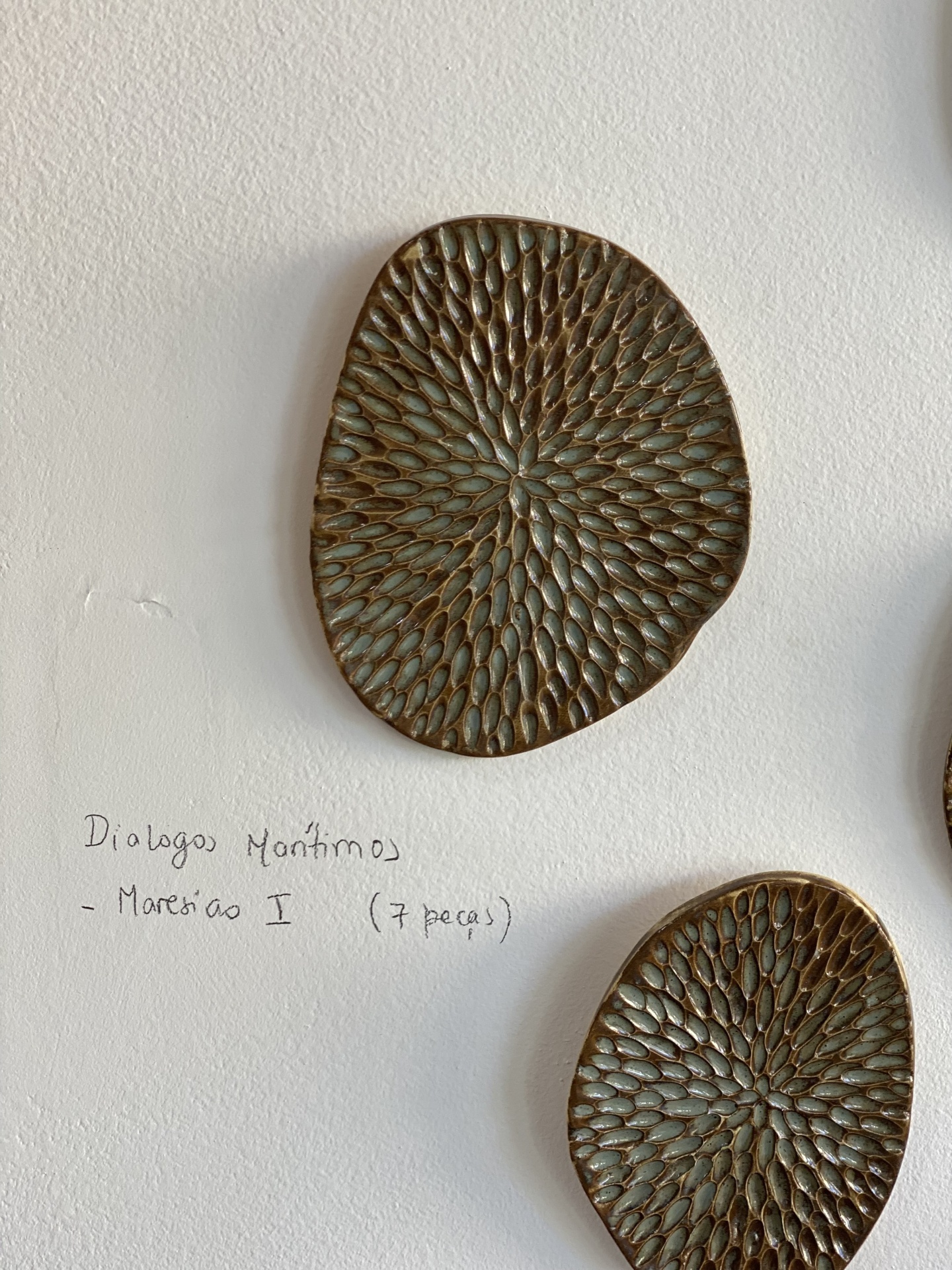 Escultura Diálogos Marítimos Pratos decorativos com textura em relevo e texto manuscrito na parede