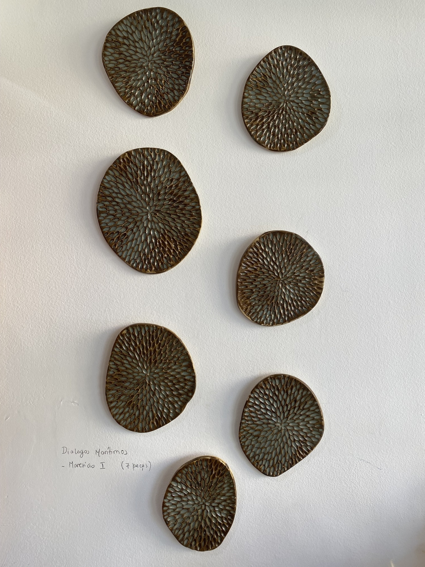 Escultura Diálogos Marítimos Peças decorativas murais castanho escuro com padrão em relevo numa parede branca