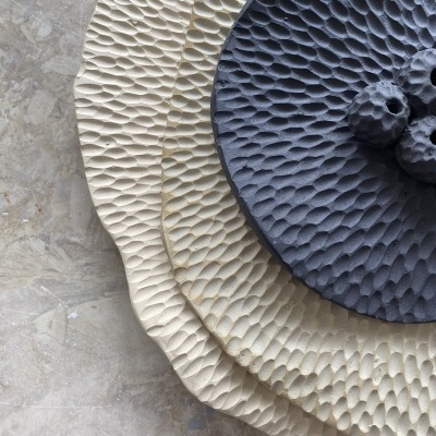 Pratos decorativos em cerâmica com relevo texturizado em tons bege e cinzento