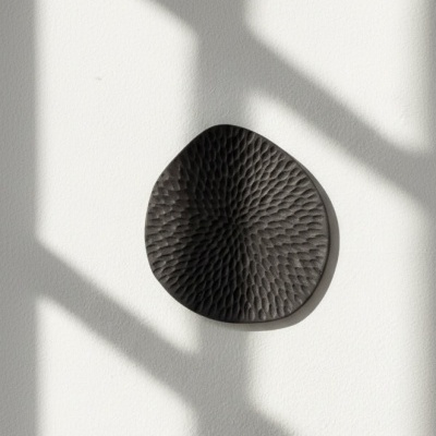 prato preto decorativo em cerâmica na parede branca com sombras de janela