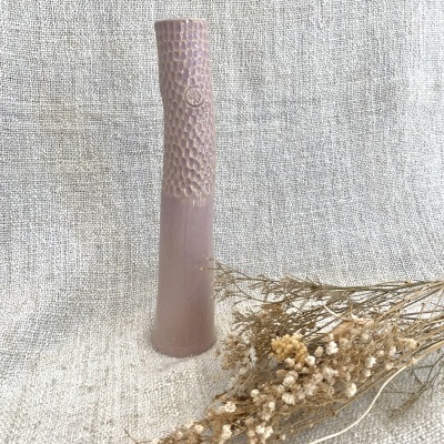 Vaso cerâmico rosa claro com textura e flores secas em tecido bege