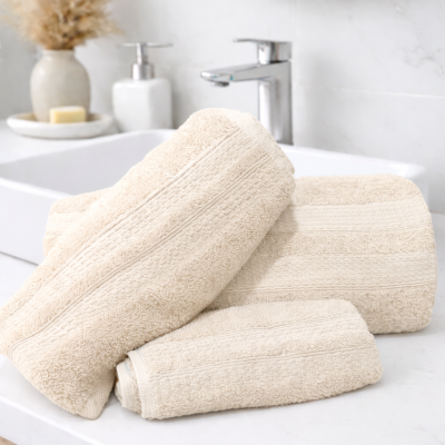 Toalhas de banho creme com padrão floral em bancada branca de casa de banho