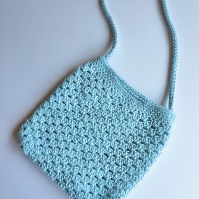 Bolsa azul claro em crochê com padrão texturizado e alça fina