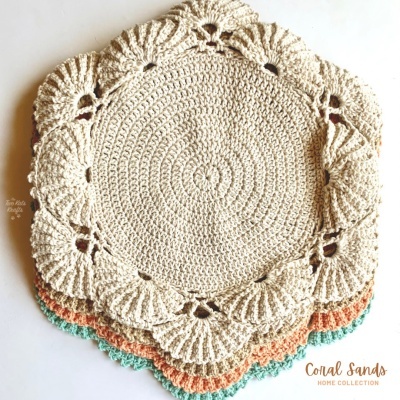 Toalhetes redondos em croché com padrão circular e bordas onduladas em cores creme, laranja e verde