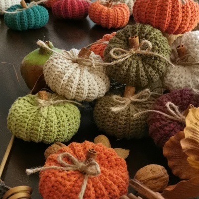 Mini abóboras decorativas de lã tricotada em várias cores sobre mesa