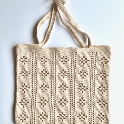 Saco de mão de malha bege com padrão de flores e alças