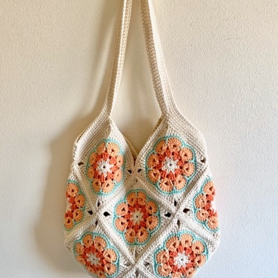 saco de croché com padrão floral colorido pendurado na parede