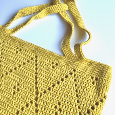Bolsa amarela em croché com padrões geométricos e alças do mesmo material