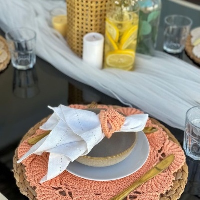 Conjunto de mesa com pratos, guardanapo e decoração em vidro com limões e flores