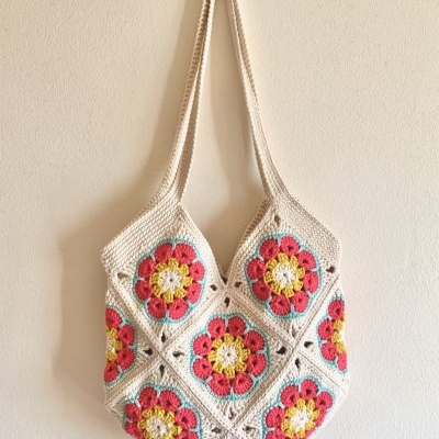 Mala de croché feita à mão com padrão floral em quadrados coloridos