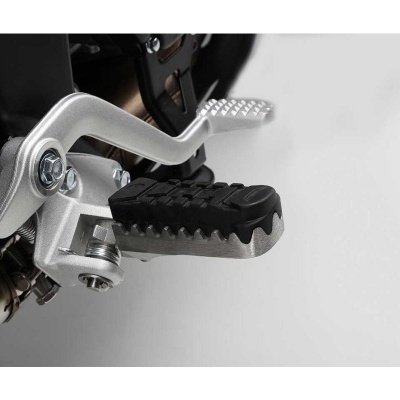 Pedaleira de mota em metal prateado com superfície preta