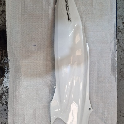 Peça lateral para motocicleta branca com inscrição XMAX