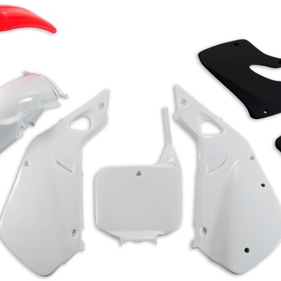 Peças plásticas para mota em várias cores, incluindo vermelho, branco e preto, dispostas em fundo branco.