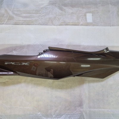 Peça lateral de motocicleta castanha metálica com acabamento brilhante