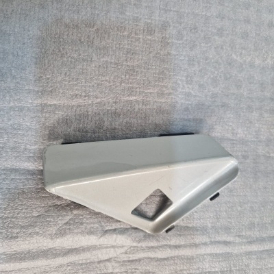 Peça plástica triangular cinza sobre fundo de tecido cinza