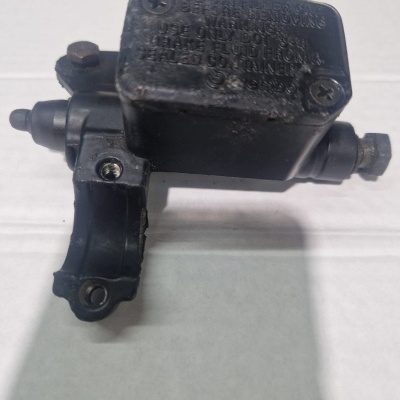 Peça mecânica preta com texto em relevo sobre superfície branca