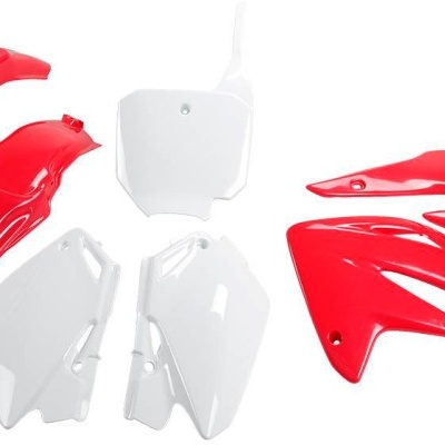 Peças plásticas vermelhas e brancas para mota sobre fundo branco