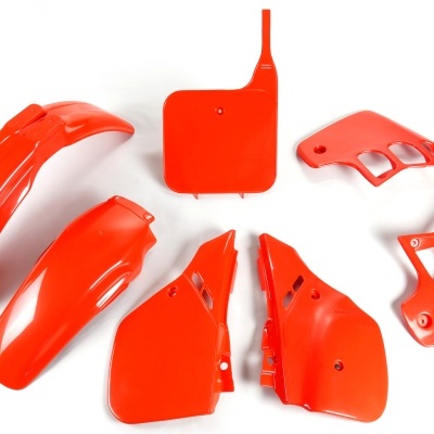 Peças vermelhas de carenagem para moto sobre fundo branco.