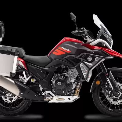 Motocicleta de aventura vermelha e preta com bagageiras de alumínio prateado