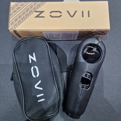 Dispositivo negro com chave, bolsa preta e caixa bege com marca ZOVii