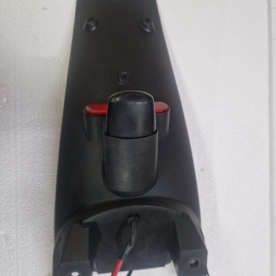 Peça traseira preta de motocicleta com reflector vermelho e cablagem exposta
