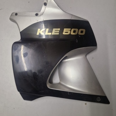 Peça de carenagem preta e cinza com texto KLE 500, sobre fundo branco.