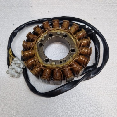 Estator com bobinas de cobre e conector branco sobre superfície branca