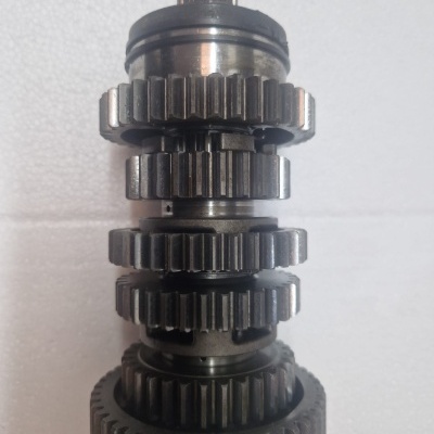 Engrenagem metálica com múltiplos dentes e vários anéis empilhados sobre fundo branco