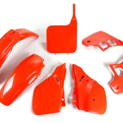 Conjunto de peças plásticas vermelhas para moto ou bicicleta sobre fundo branco