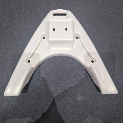 Estrutura plástica branca triangular com orifícios sobre superfície escura